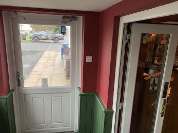 In porch, showing outer door on left and double door to pub.