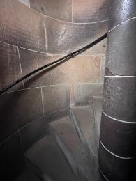 Dark, winding stairwell with handrail.