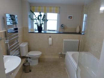 En-suite bathroom to double bedroom with bath and shower over