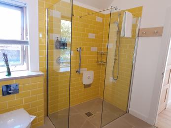 Slackbrae yellow bathroom shower seat. Please note that the glass walls are not movable.