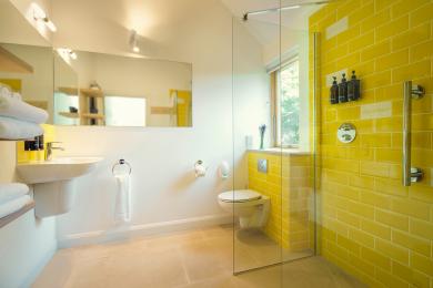 Slackbrae yellow bathroom with walk-in shower. Please note that the glass walls are not movable.