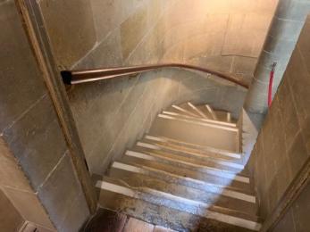 Spiral staircase with handrail on the left wall. 14 steps to the Chapel. 