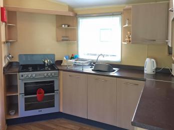 Fitted open plan kitchen has normal height work surfaces