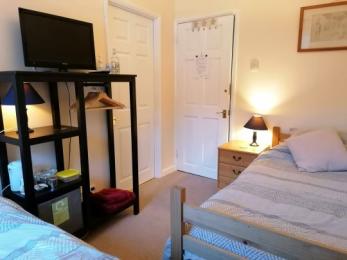 Twin beds, clothes rail, bedroom entrance and entrance to bathroom