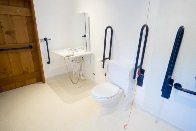 Wet-room, with contrasting floor , timber and safety rails, red emergency cord.coin turn door lock. 