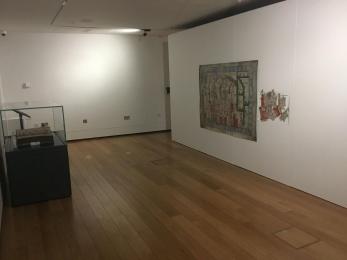 Image shows the layout of the Hardyng map exhibition from the back. There is a map on the right and a glass cabinet on the left