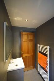Image is of the inside of the bathroom, taken from the toilet/shower end and looking to doorway