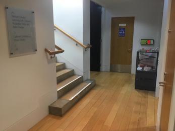 Image shows corridor between gallery 4 and the exit to the shop. The stairs to the first floor can also been seen on the left. 
