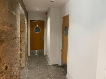 Image shows toilet entrance. Women toilet door on right, men's toilet door straight ahead