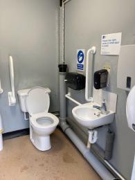 Visitor accessible toilet showing toilet and sink, plus grab handles