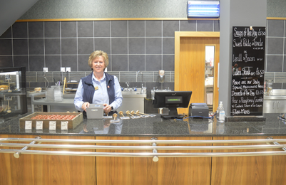 A member of staff at the food ordering point at the start of our food service section.