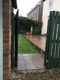 View through side gate to rear garden and patio