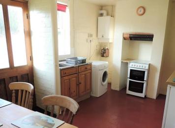 kitchen with dining table, sink, oven and washing machine