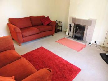Living room with red settees and fireplace