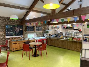 Visitor centre café showing counter with till, queue area, and counter with cutlery, conditments and water