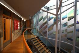 View of interior atrium of Museum showing glass windows and staircase with bannister.