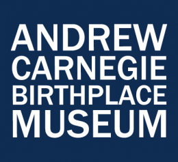 White text on navy blue blackground reads Andrew Carnegie Birthplace Museum.