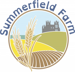 Summerfield Farm circular logo containing three wheat sheafs, fields and Whitby Abbey in the background