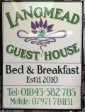 Hand written sign showing Langmead Guest House with lavender logo Bed & Breakfast Est 2010 Tel 01843 582 785 Mobile 07971 781131
