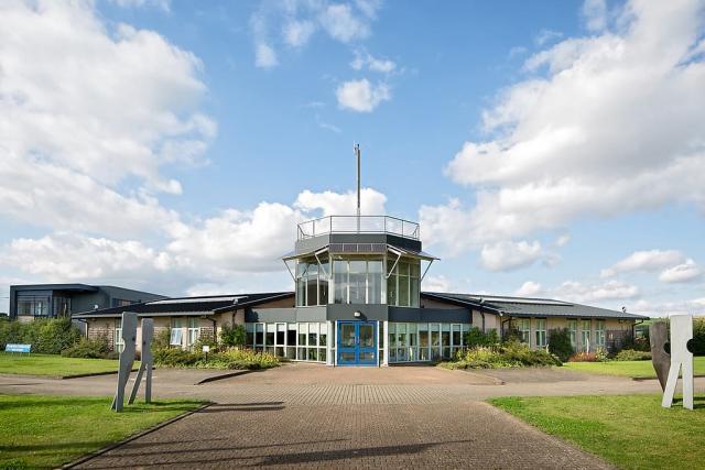 Front of Markham Vale Environment Centre with steel figures on the Walking Together Memorial Trail to the left and right,
