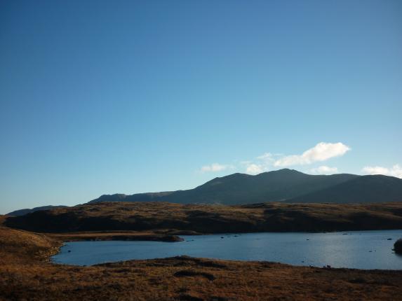 Loch Druidibeg Nature Reserve bathed in winter sunshine. The loch echoes the colours of the sky, with the hills sillouetted. 