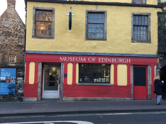 A yellow building with a red façade and the words 'Museum of Edinburgh' in white.