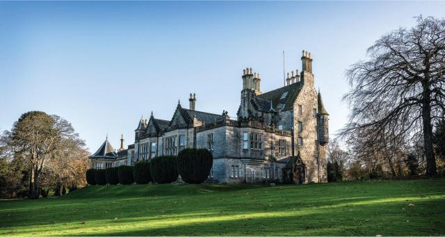 A green lawn in front of Lauriston Castle and a blue sky.